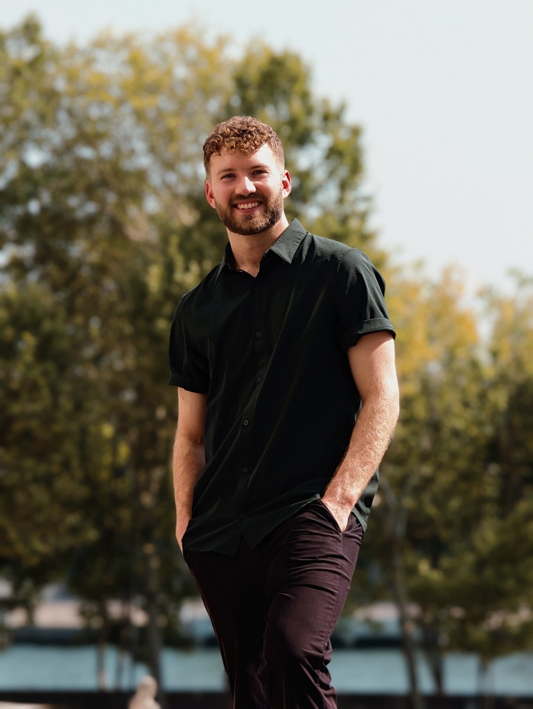 Image of a man standing and smiling at the camera
