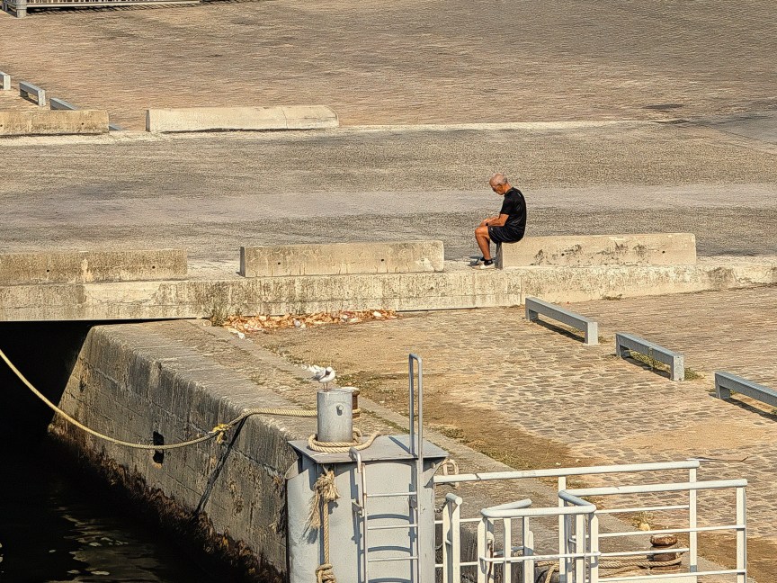 Image of a man sitting on a wall