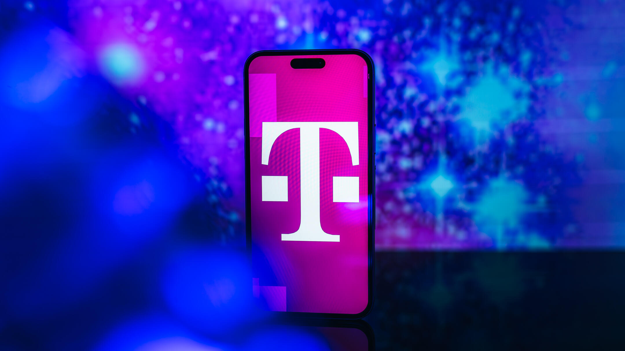 mobile carrier logo on phone screen against blue backdrop