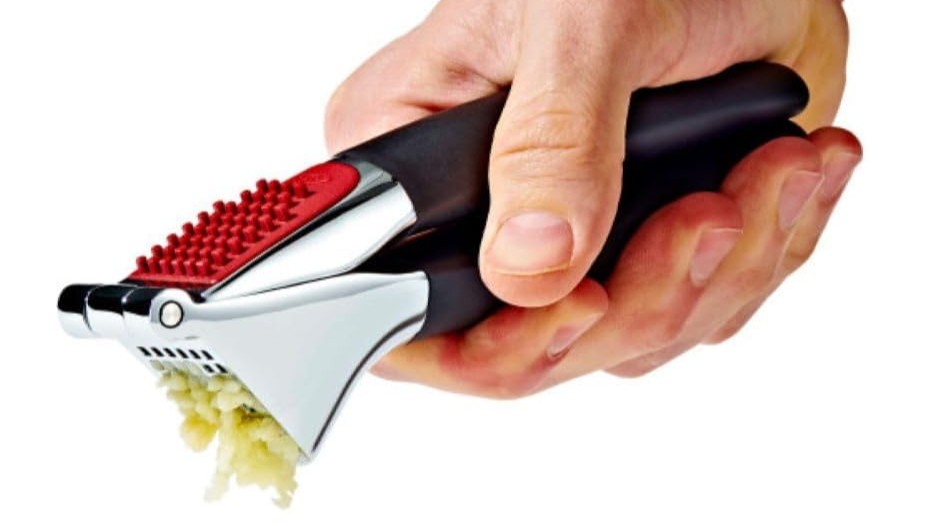 oxo garlic press squeezing out garlic