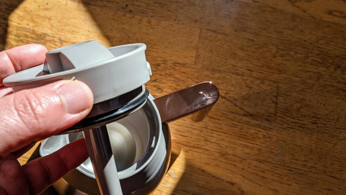 hand holding parts of coffee maker