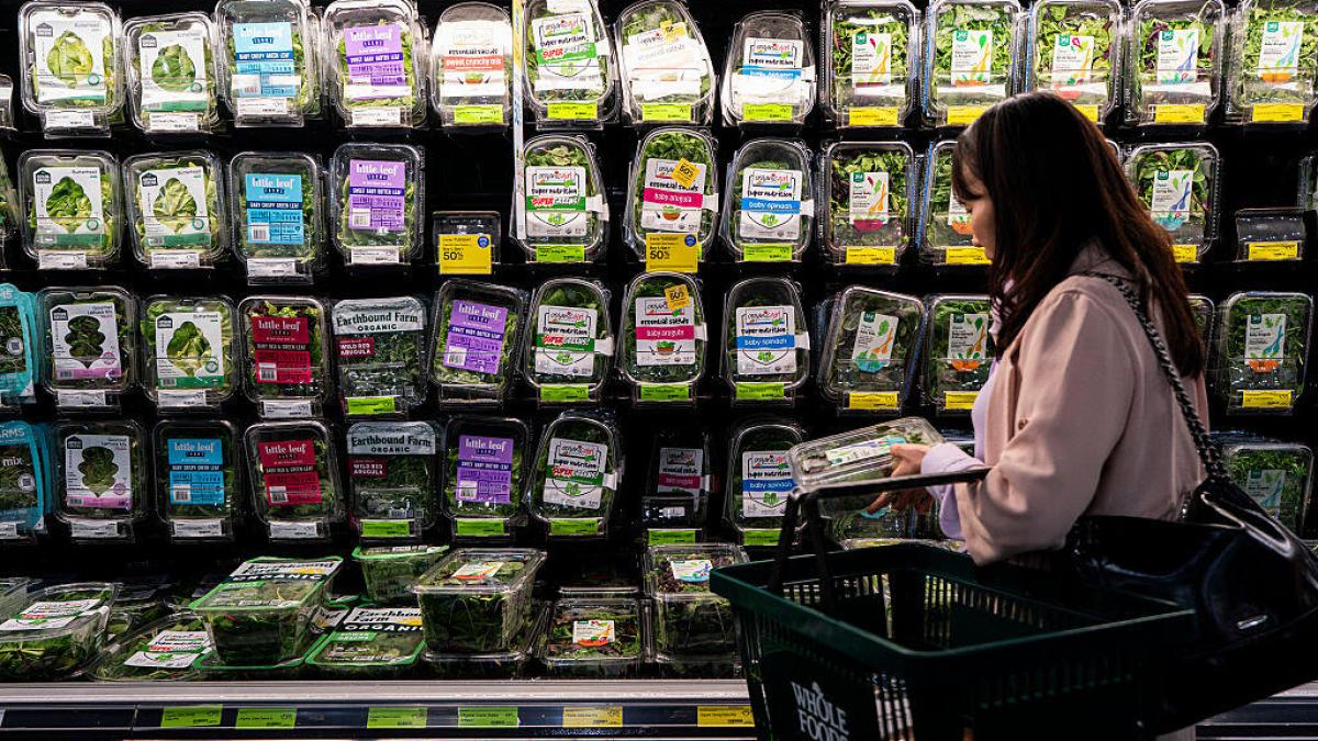 Arugula, kale, romaine lettuce, and salad greens for sale at a grocery store