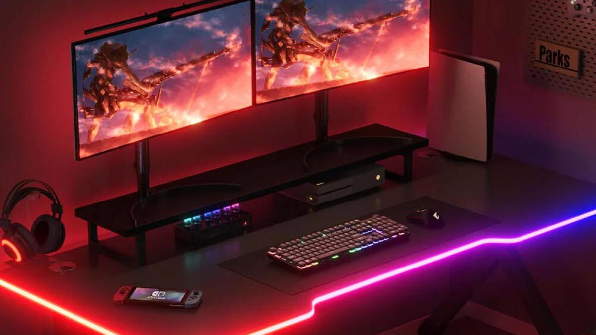 Govee's light strip glowing with multiple colors around a gaming desk.