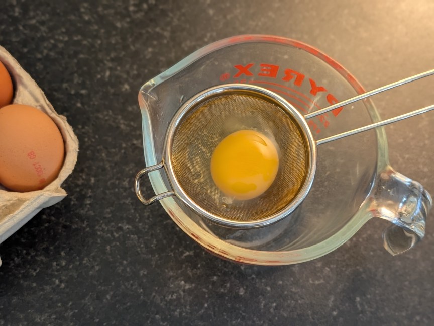 Raw egg being strained