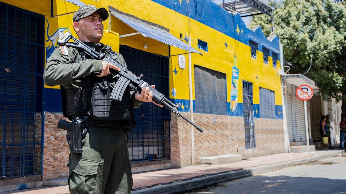 A police officer stands guard on a street following a military operation against the drug-related armed group Conquering Self Defense Forces of the Sierra Nevada (ACSN) in Santa Marta, Colombia