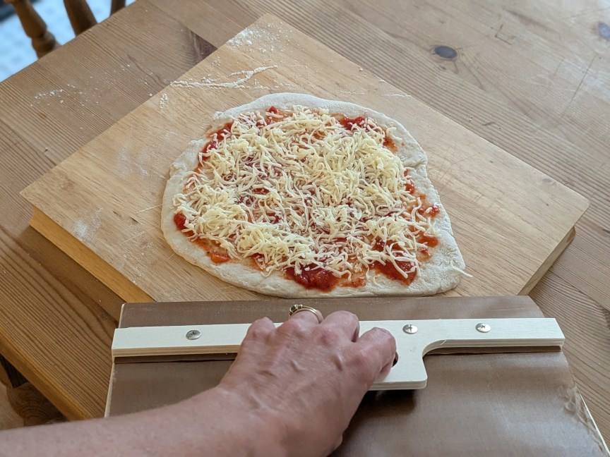 pizza peel lifting uncooked pizza 