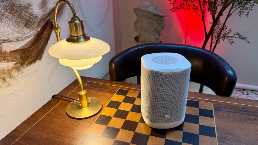 The JBLCove M1 speaker shown sitting on table with a chess board embedded in it