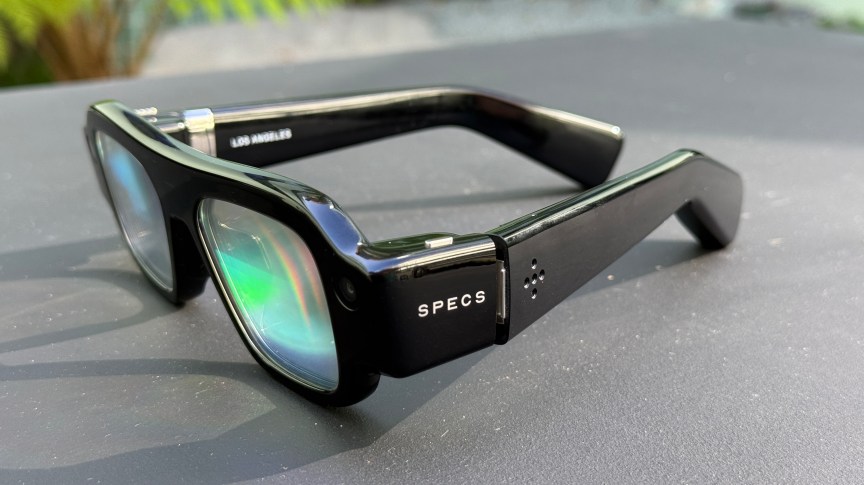 A side view of black Snap Specs AR glasses with rainbow-tinted lenses