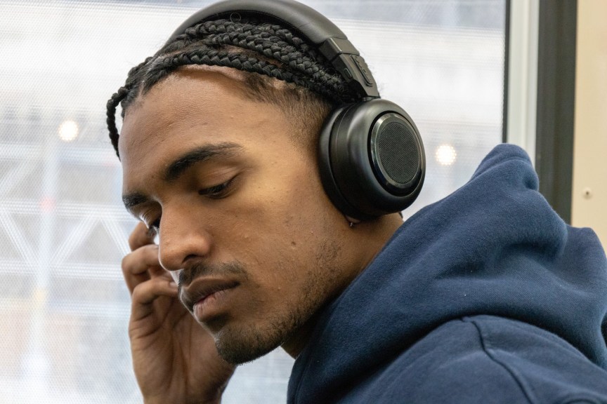 A man wearing TDM Neo headphones in a sweatshirt.