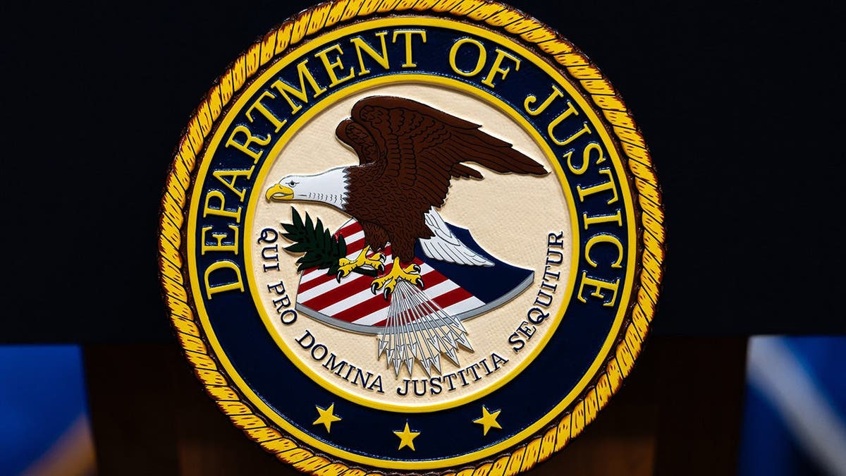 U.S. Department of Justice logo displayed on a podium.